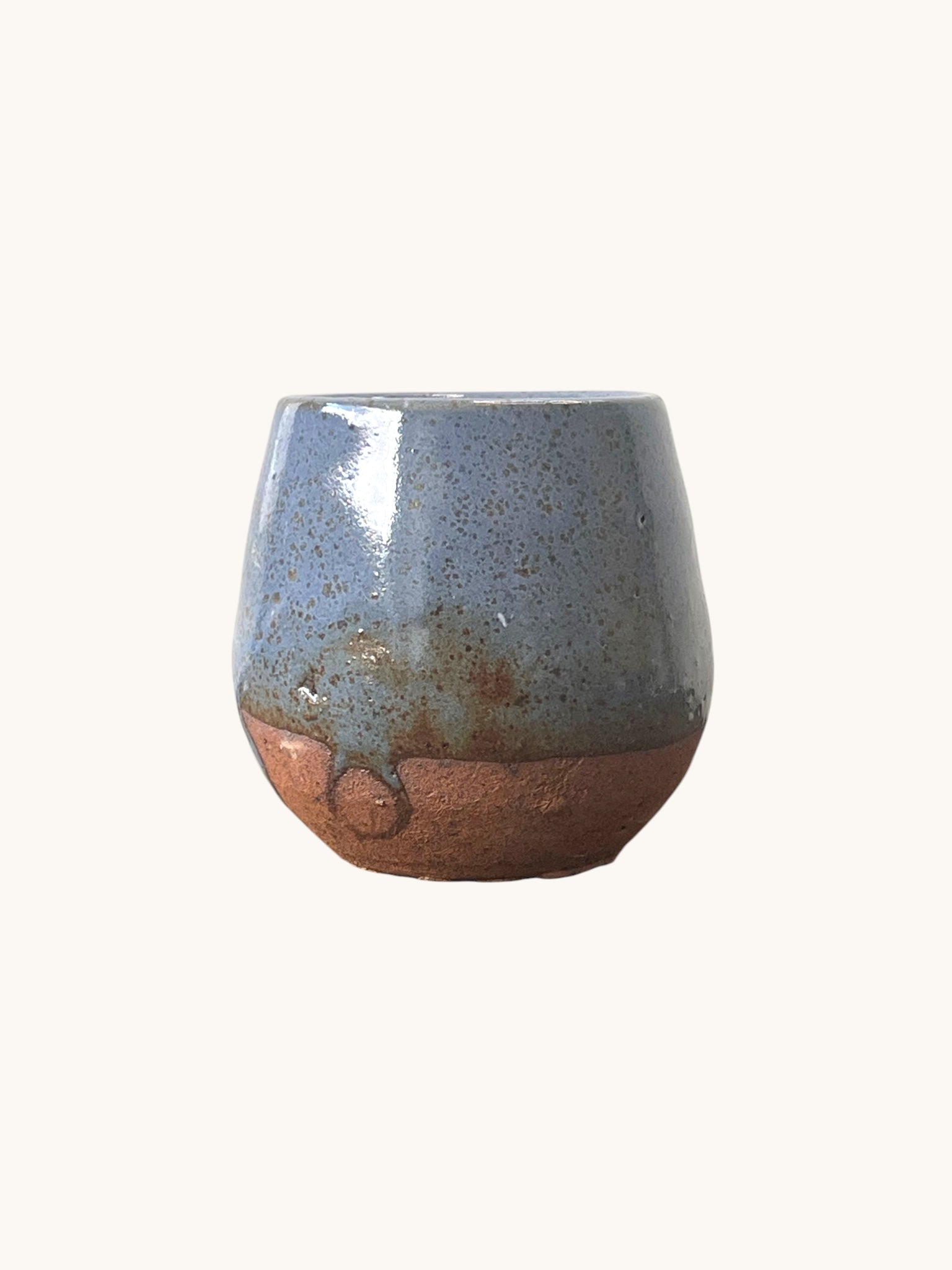 Matera Rob Original en gres con vidriado azul grisáceo brillante y base terracota sin vidriar, fondo blanco. Matera Rob®
