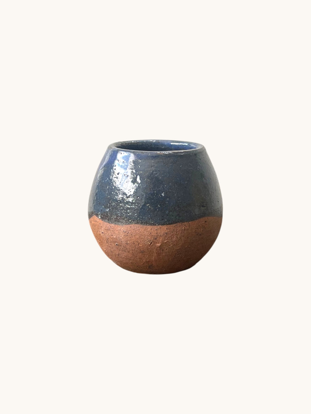 Matera Rob Original en gres con vidriado azul cobalto, vista frontal sobre fondo blanco cálido, mostrando base terracota descubierta. Matera Rob®
