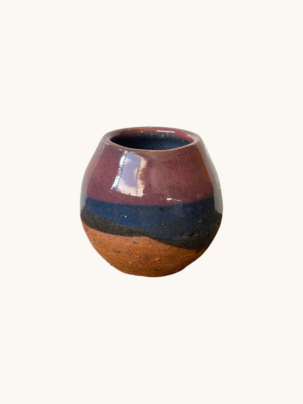 Matera Rob Original en gres con vidriado rosa malva y franja azul marino, forma redonda, base terracota descubierta, fondo blanco cálido. Matera Rob®
